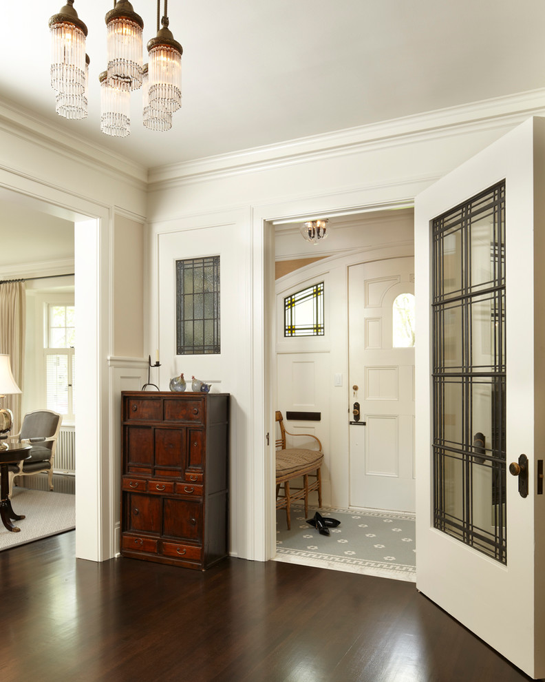 Imagen de vestíbulo tradicional con suelo de madera oscura, puerta simple y puerta blanca