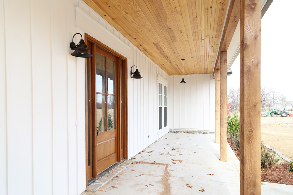 Идея дизайна: входная дверь среднего размера в стиле кантри с белыми стенами, бетонным полом, одностворчатой входной дверью и входной дверью из дерева среднего тона