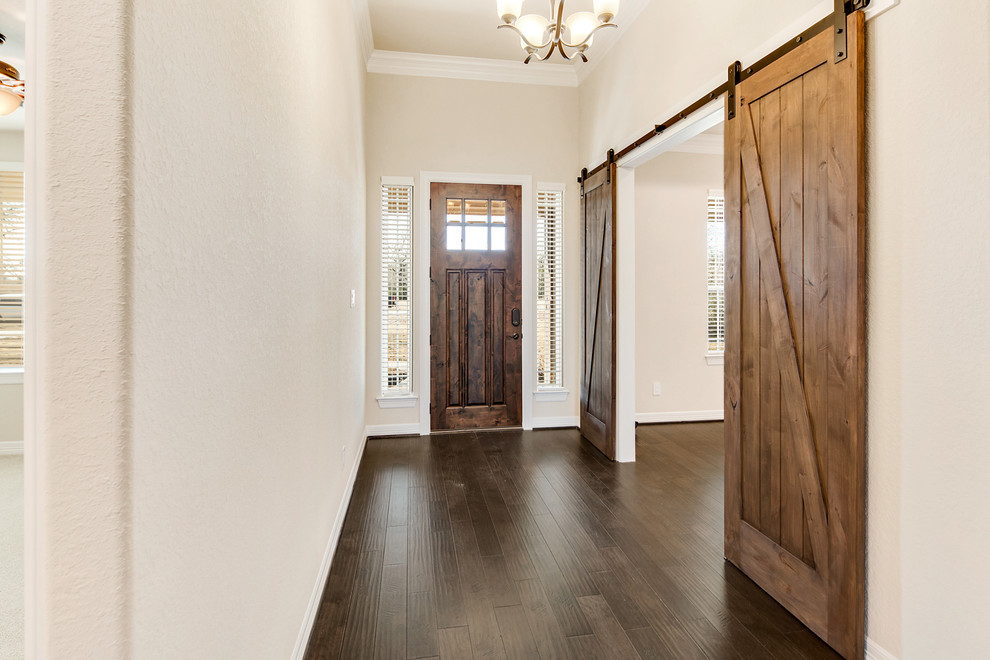 Inspiration for a medium sized rural foyer in Houston with beige walls, dark hardwood flooring, a single front door, a dark wood front door and brown floors.