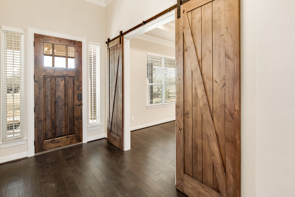 Mittelgroßes Landhaus Foyer mit beiger Wandfarbe, dunklem Holzboden, Einzeltür, dunkler Holzhaustür und braunem Boden in Houston