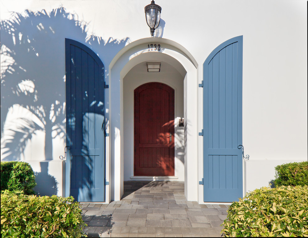 Imagen de entrada marinera con paredes blancas, puerta doble y puerta azul