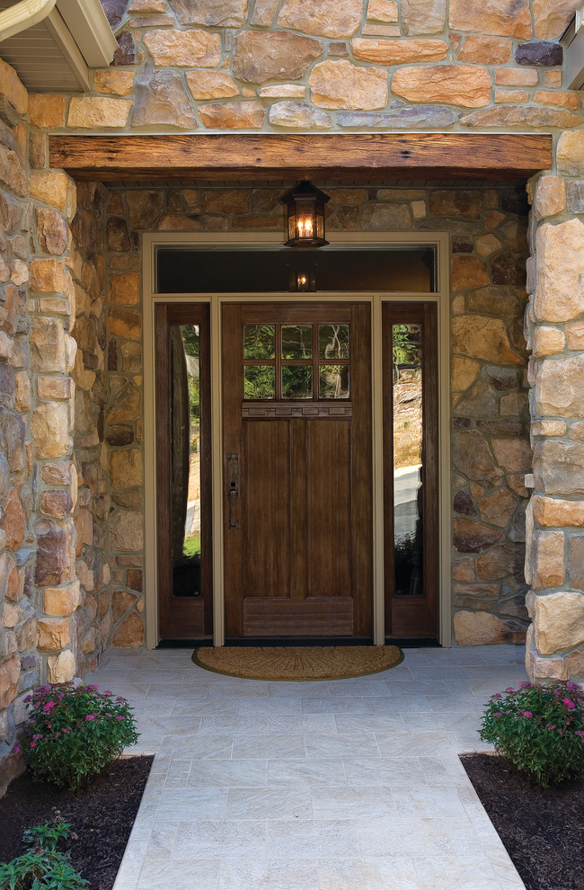 Cette image montre une porte d'entrée chalet avec une porte simple et une porte en bois foncé.