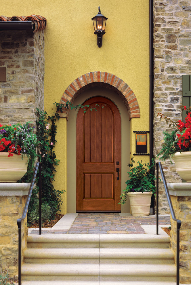 Foto di una porta d'ingresso mediterranea con una porta singola e una porta in legno bruno