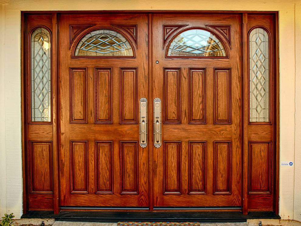 На фото: огромная входная дверь в классическом стиле с бежевыми стенами, двустворчатой входной дверью и входной дверью из дерева среднего тона