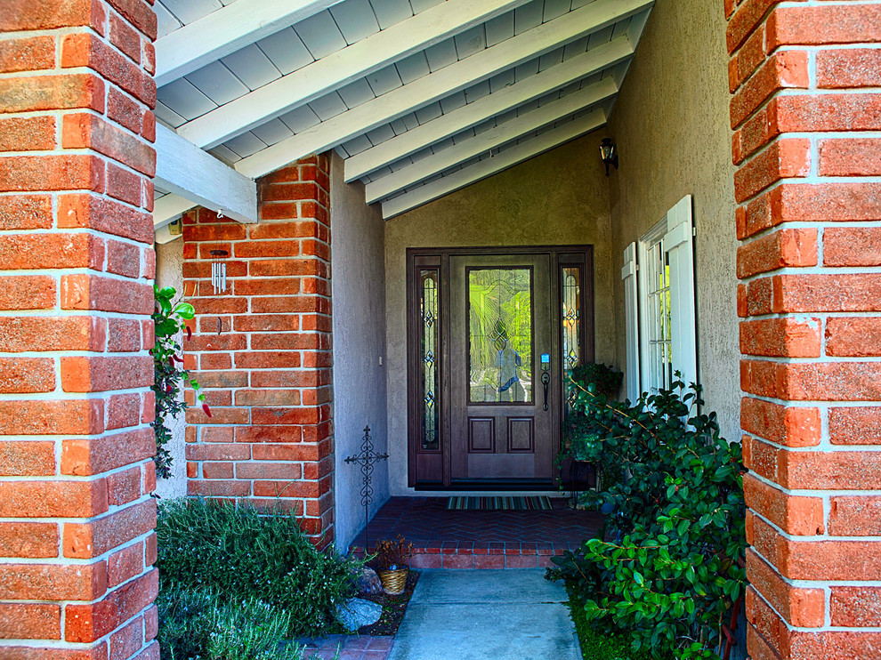 オレンジカウンティにある広いトラディショナルスタイルのおしゃれな玄関ドア (白い壁、木目調のドア) の写真