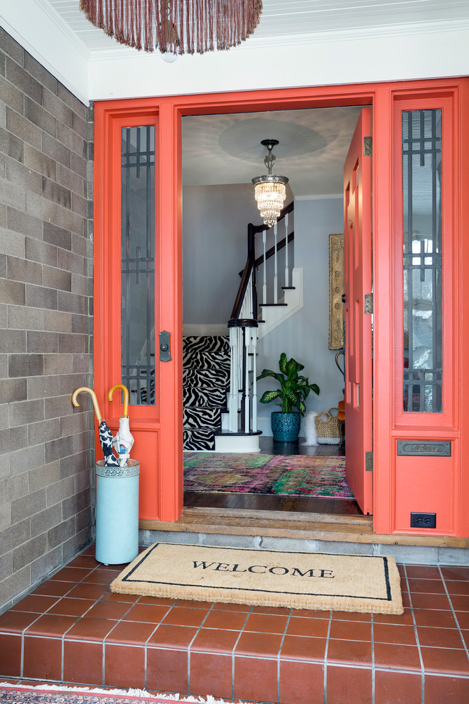 Idée de décoration pour une porte d'entrée bohème avec un mur gris, une porte simple et une porte orange.