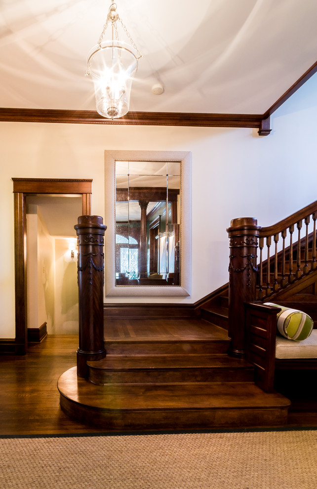 This is an example of an expansive traditional foyer in Kansas City with beige walls and dark hardwood flooring.