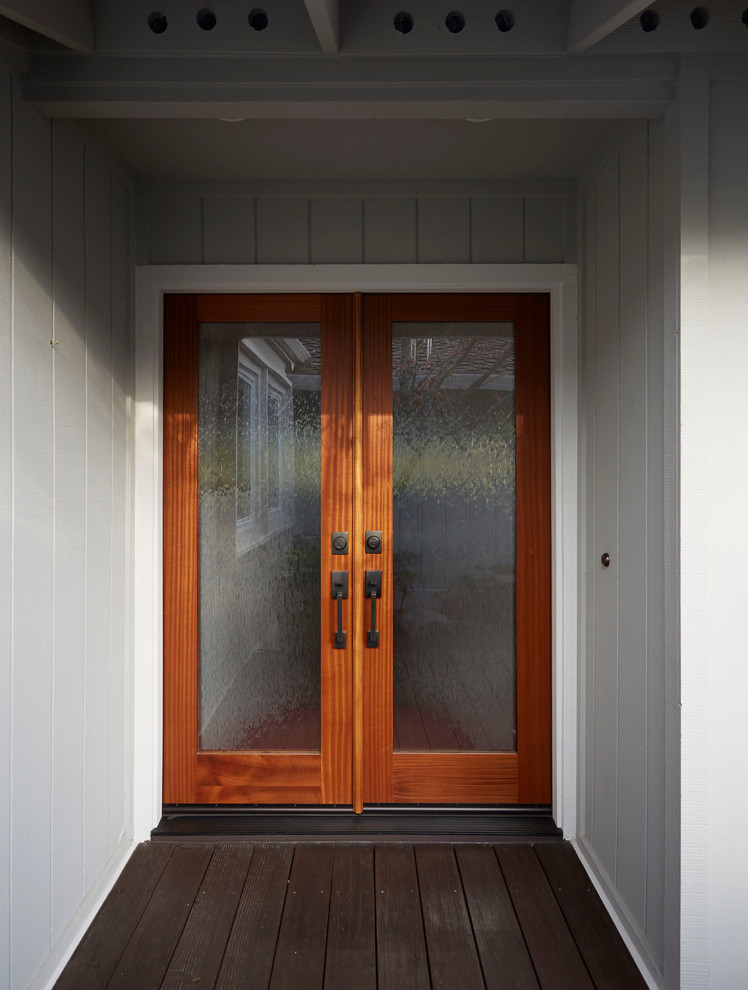 Modelo de puerta principal retro con paredes grises, suelo de madera oscura, puerta doble y puerta de madera en tonos medios