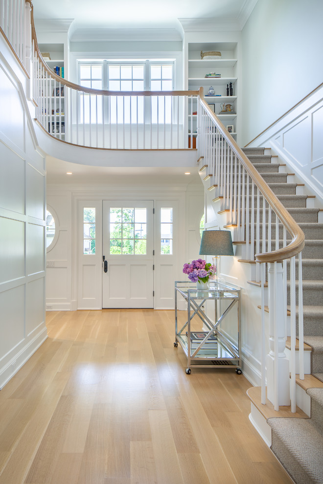 This is an example of a medium sized nautical foyer in New York with white walls, light hardwood flooring, a stable front door, a white front door, beige floors and feature lighting.