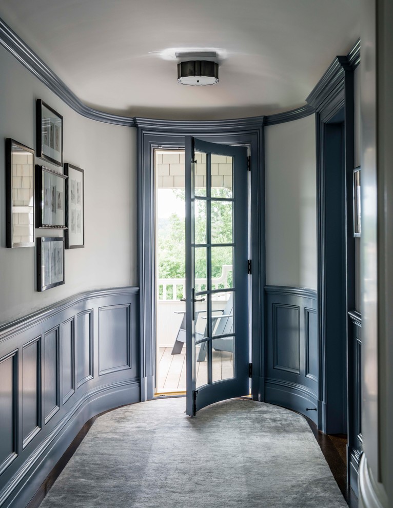 Esempio di un piccolo corridoio stile marinaro con pareti bianche, una porta singola, una porta in vetro, pavimento in legno massello medio e pavimento marrone
