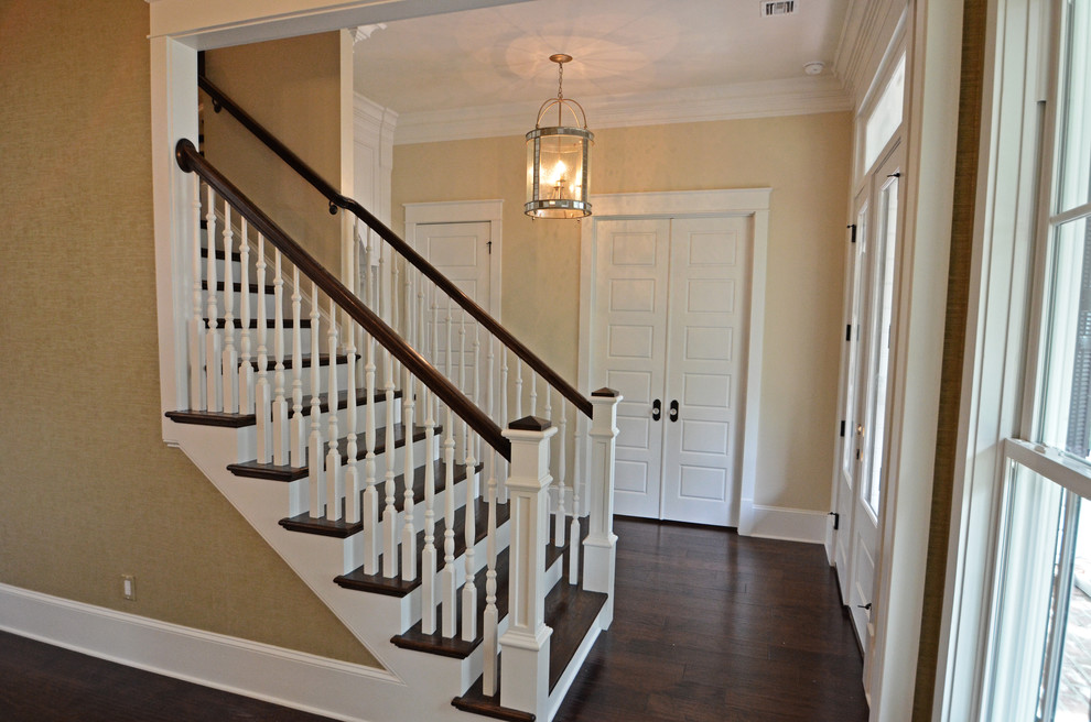 Foto di un corridoio tradizionale di medie dimensioni con pareti beige, parquet scuro, una porta a due ante e una porta bianca