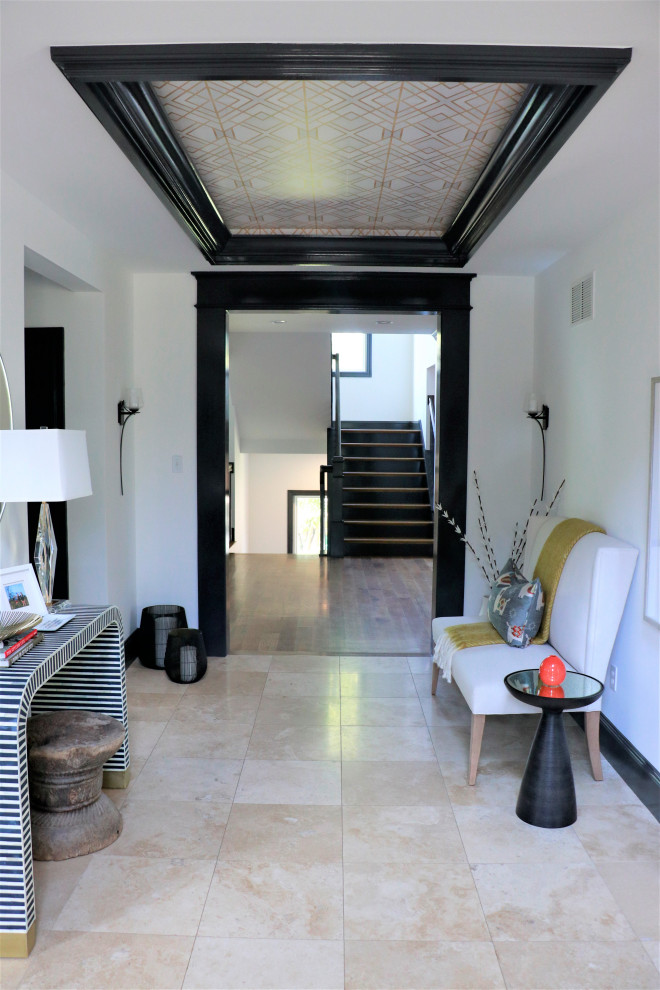 Cette image montre un hall d'entrée minimaliste de taille moyenne avec un mur blanc et un sol en marbre.