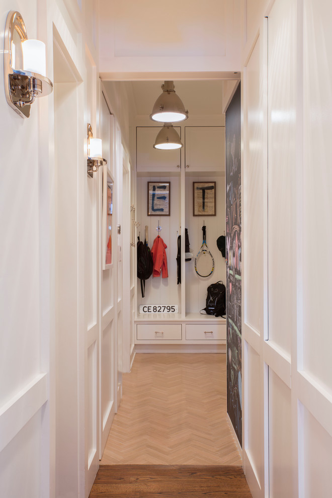 This is an example of a large traditional boot room in DC Metro with white walls.