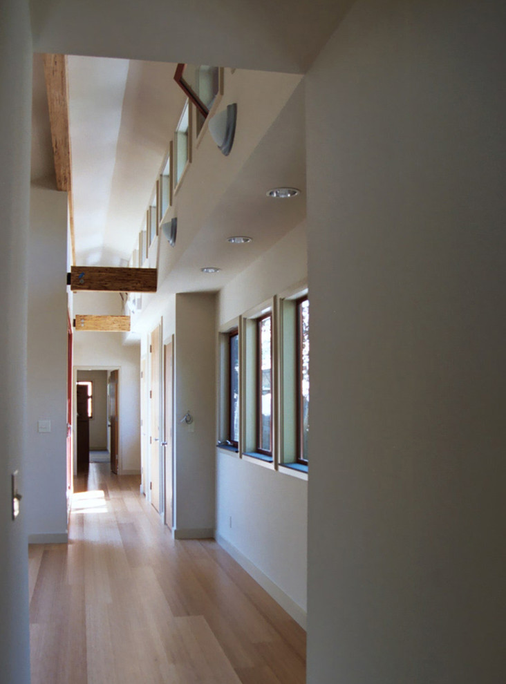 Ejemplo de hall actual pequeño con paredes blancas, suelo de bambú, puerta simple, puerta roja y suelo beige