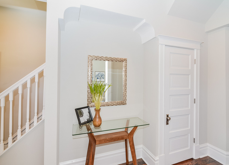 Aménagement d'une porte d'entrée classique de taille moyenne avec un mur gris, parquet foncé, une porte double et une porte blanche.