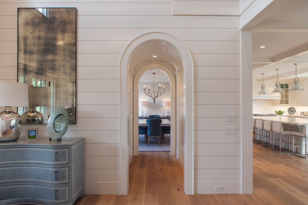 Ispirazione per un ingresso stile marino con pareti bianche e pavimento in legno massello medio