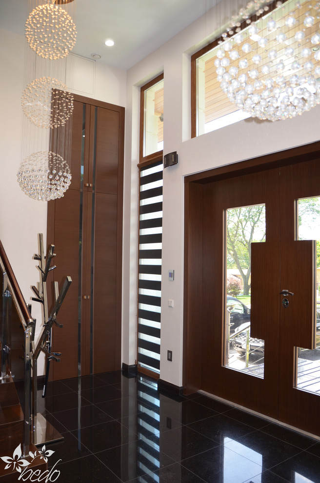 Esempio di un grande corridoio minimalista con pareti beige, pavimento in gres porcellanato, una porta a due ante e una porta in legno scuro