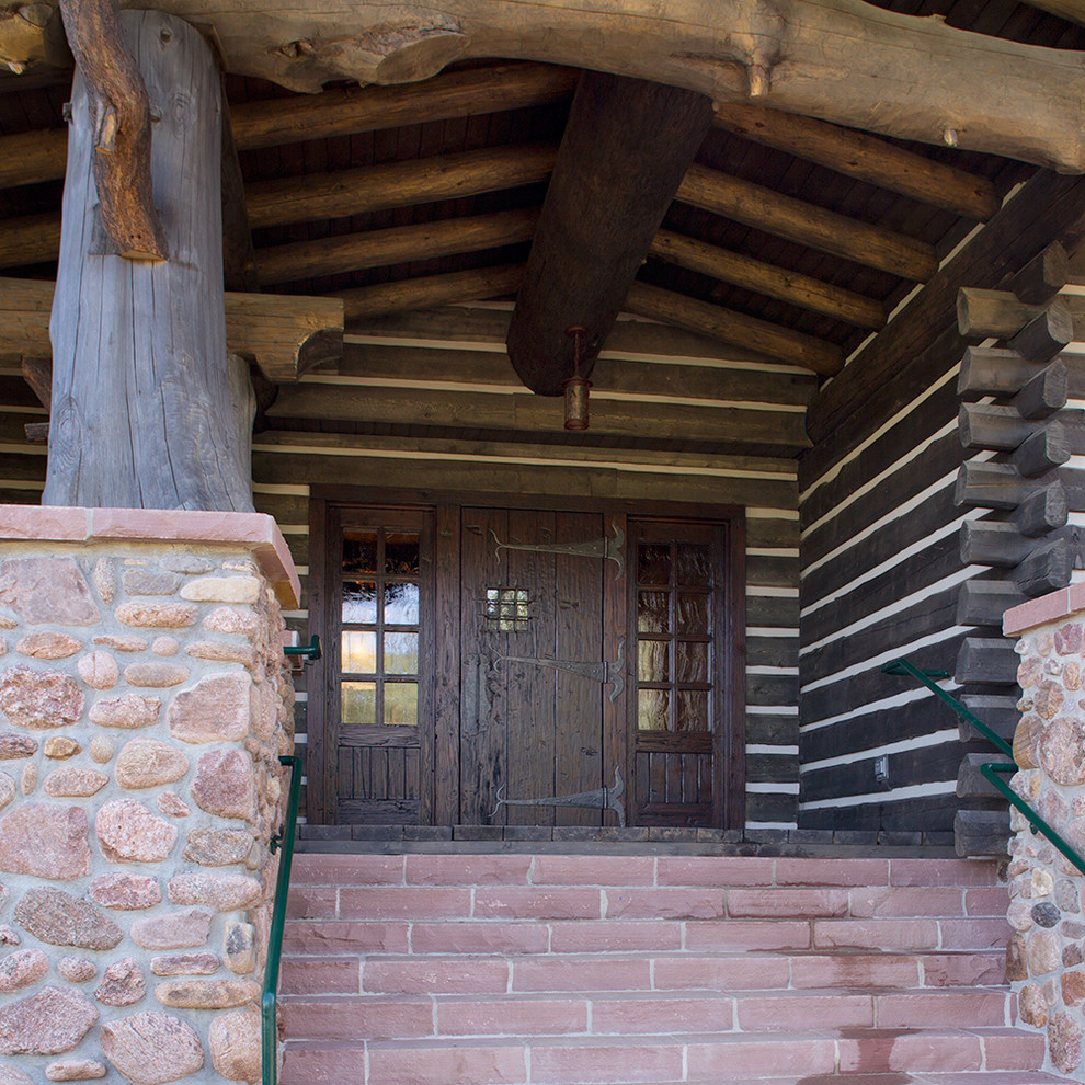 Aménagement d'une très grande porte d'entrée montagne avec parquet foncé, une porte simple et une porte en bois foncé.