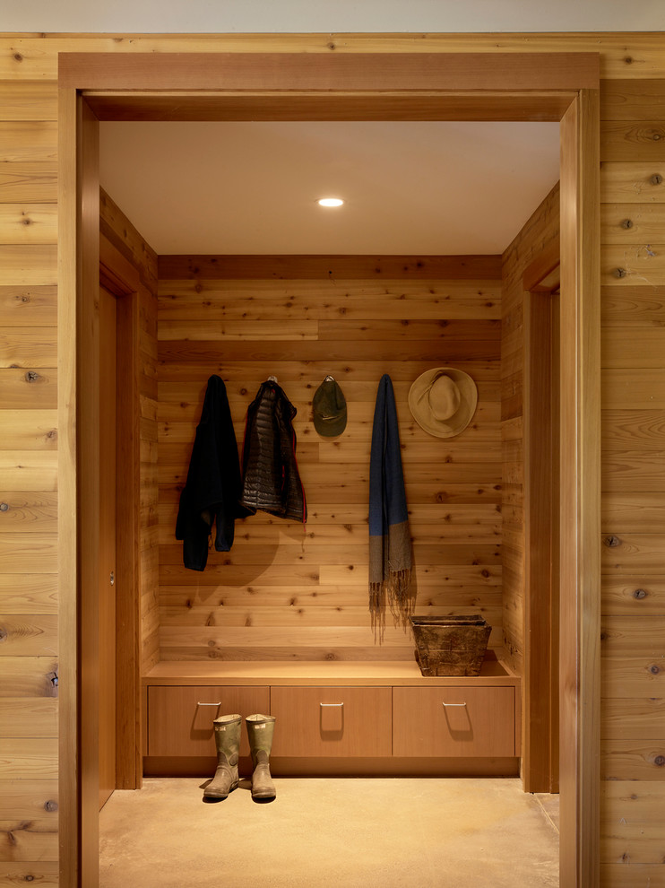 Rural boot room in San Francisco with concrete flooring, brown walls and grey floors.