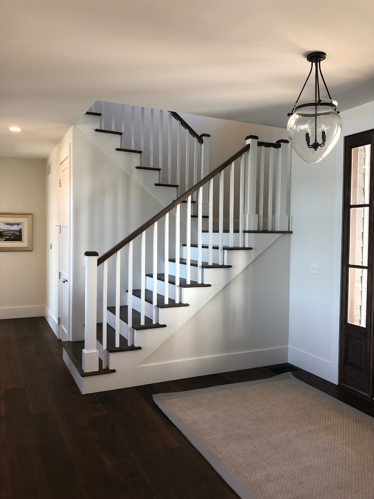 Inspiration for a mid-sized timeless medium tone wood floor entryway remodel in Other with white walls and a dark wood front door