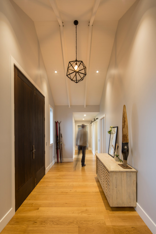 Idée de décoration pour un hall d'entrée design de taille moyenne avec un mur gris, un sol en bois brun, une porte double, une porte en bois foncé et un sol marron.