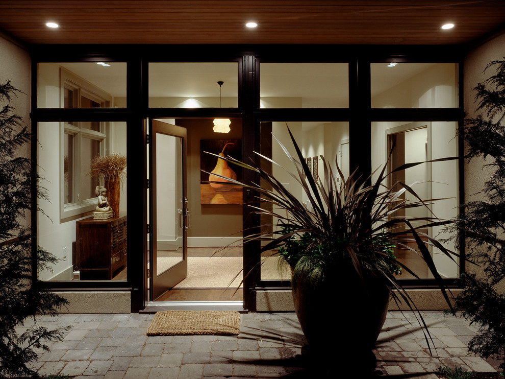 Example of a trendy medium tone wood floor entryway design in Seattle with white walls and a black front door
