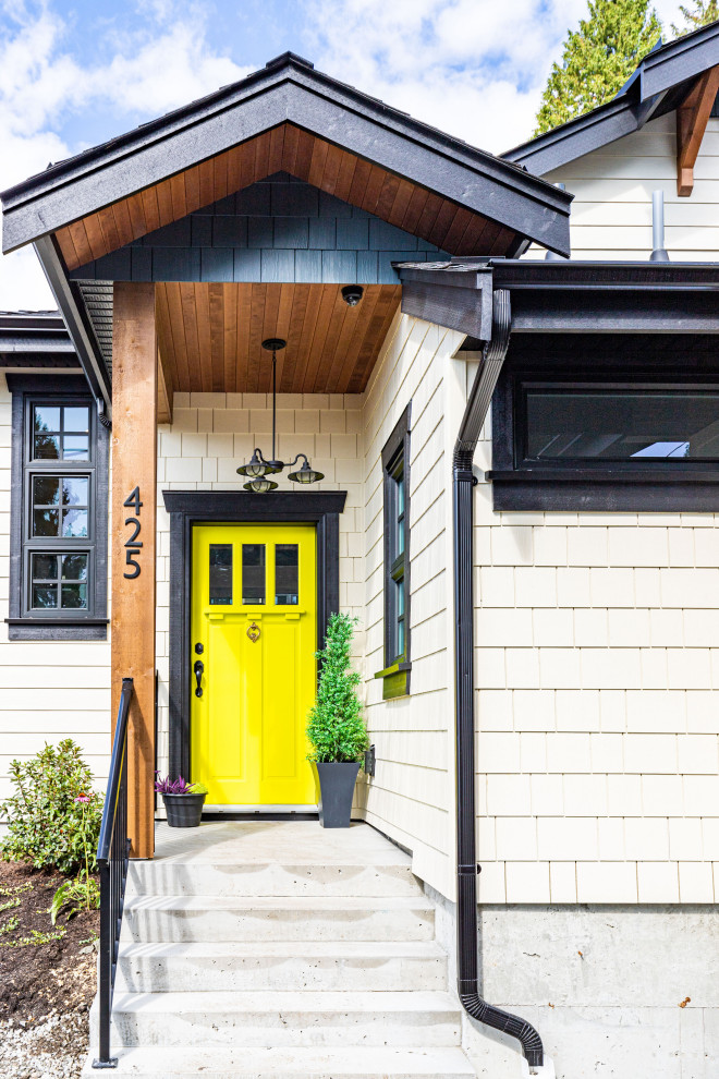 Свежая идея для дизайна: прихожая среднего размера в стиле кантри с одностворчатой входной дверью, желтой входной дверью, бежевыми стенами, бетонным полом и серым полом - отличное фото интерьера