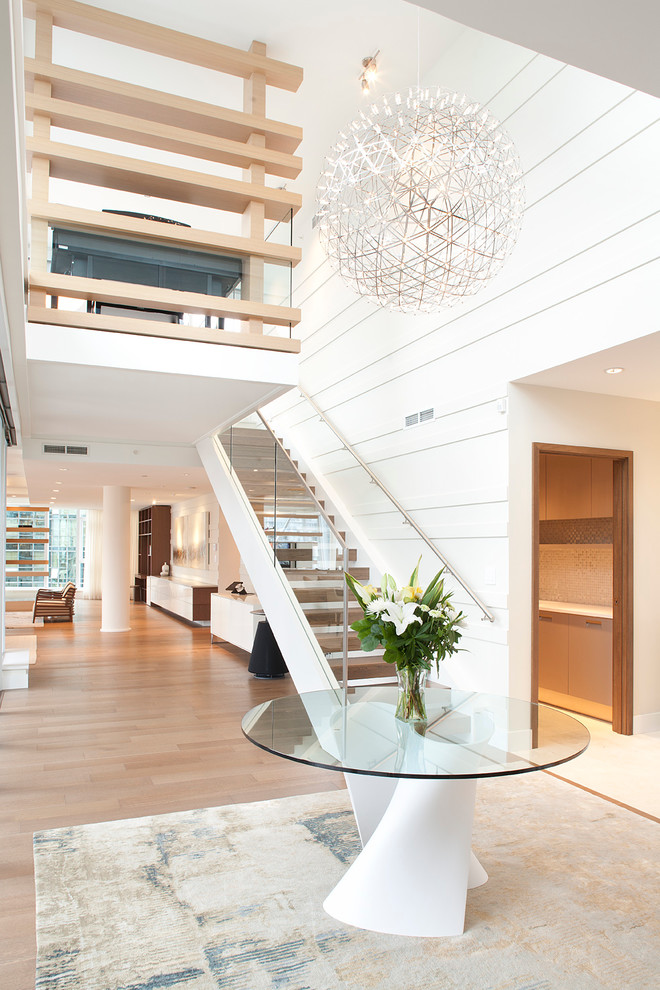 Photo of a contemporary foyer in Vancouver with white walls and light hardwood flooring.