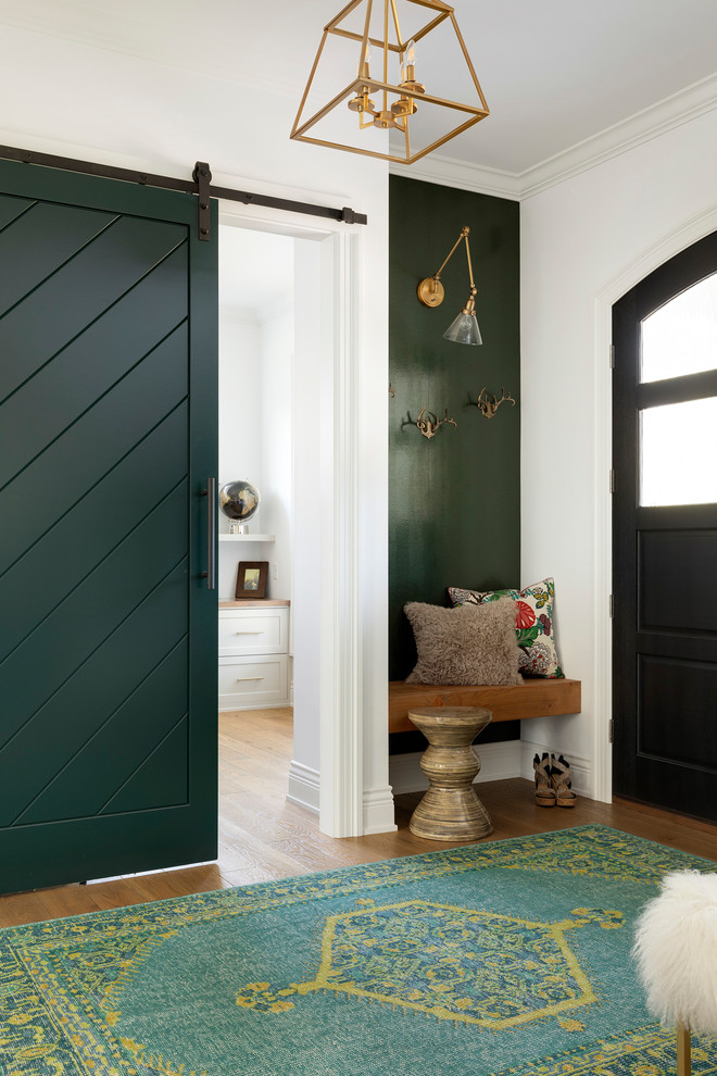 Ispirazione per un ingresso stile marino di medie dimensioni con pareti bianche, pavimento in legno massello medio, una porta a due ante, una porta nera e pavimento beige