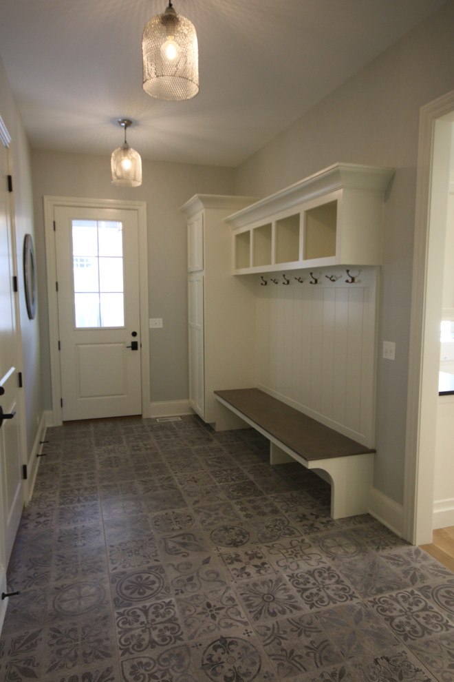 Aménagement d'une petite entrée craftsman avec un vestiaire, un mur gris, un sol en carrelage de céramique, une porte simple, une porte blanche et un sol gris.