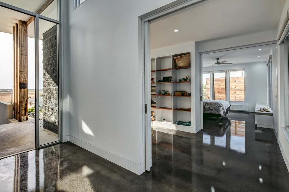 Источник вдохновения для домашнего уюта: большая входная дверь в морском стиле с белыми стенами, бетонным полом и одностворчатой входной дверью