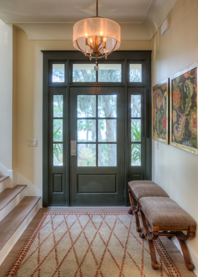 Ispirazione per un ingresso classico di medie dimensioni con pareti beige, pavimento in legno massello medio, una porta singola, una porta verde e pavimento marrone