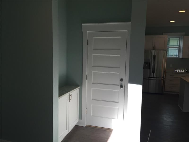 Beach style medium tone wood floor mudroom photo in Tampa with blue walls