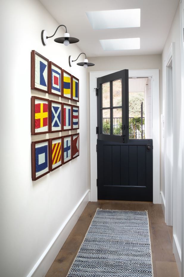 Kleine Maritime Haustür mit weißer Wandfarbe, braunem Holzboden, Klöntür, schwarzer Haustür und braunem Boden in Los Angeles