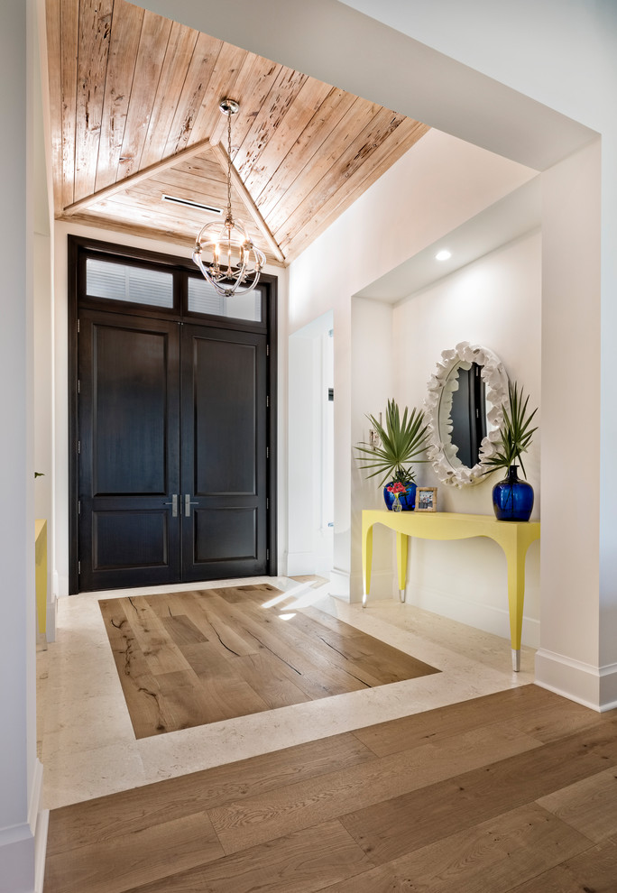 Aménagement d'une entrée classique avec parquet clair, une porte double, une porte en bois foncé et un sol beige.