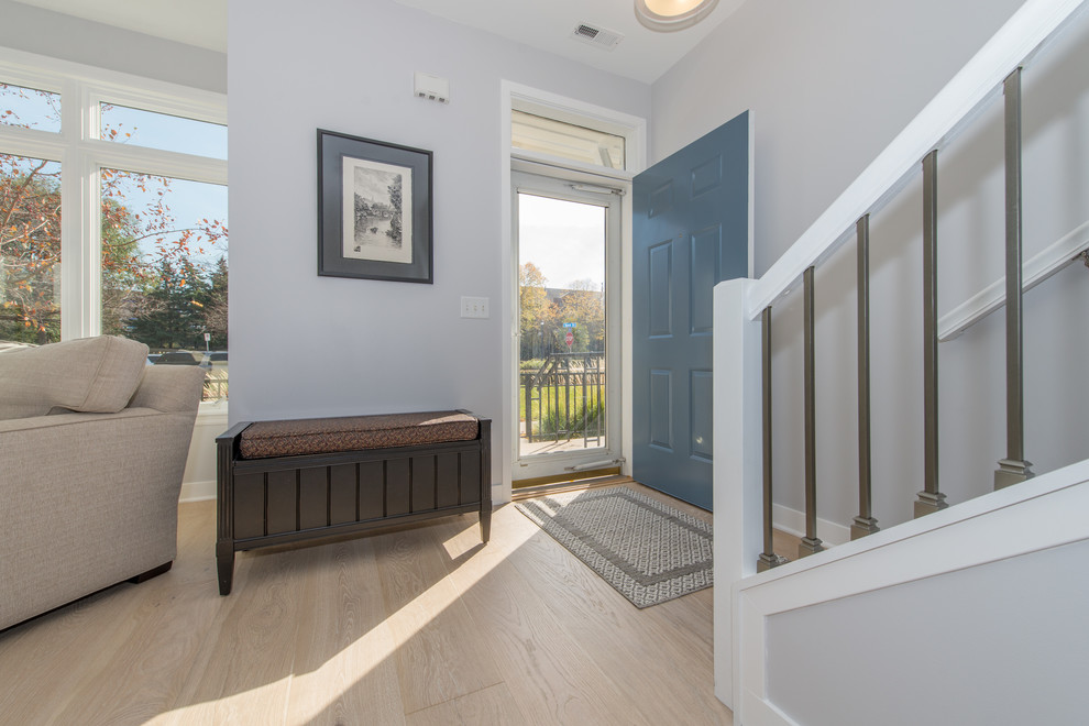 Cette image montre une porte d'entrée rustique de taille moyenne avec un mur gris, parquet clair, une porte simple, une porte bleue et un sol blanc.