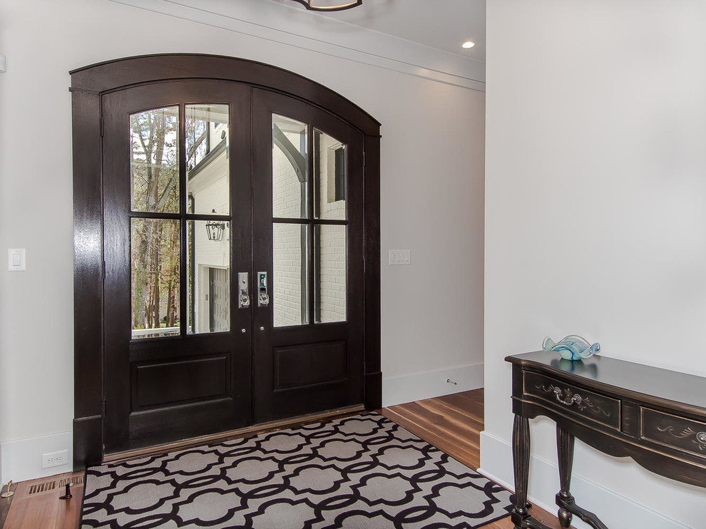 Стильный дизайн: узкая прихожая среднего размера в классическом стиле с белыми стенами, светлым паркетным полом, двустворчатой входной дверью, входной дверью из темного дерева и белым полом - последний тренд