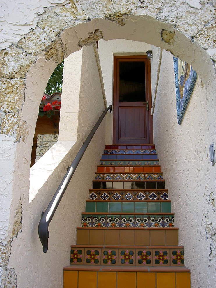 This is an example of a mediterranean front door in Miami with a single front door and a dark wood front door.