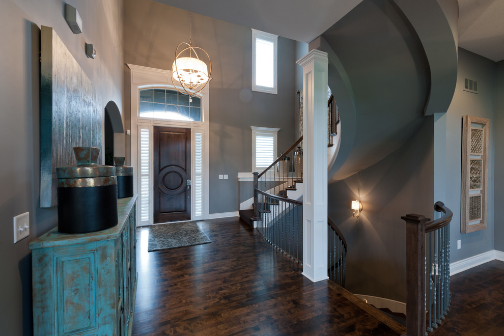 Example of a mid-sized transitional dark wood floor and brown floor entryway design in Kansas City with gray walls and a medium wood front door