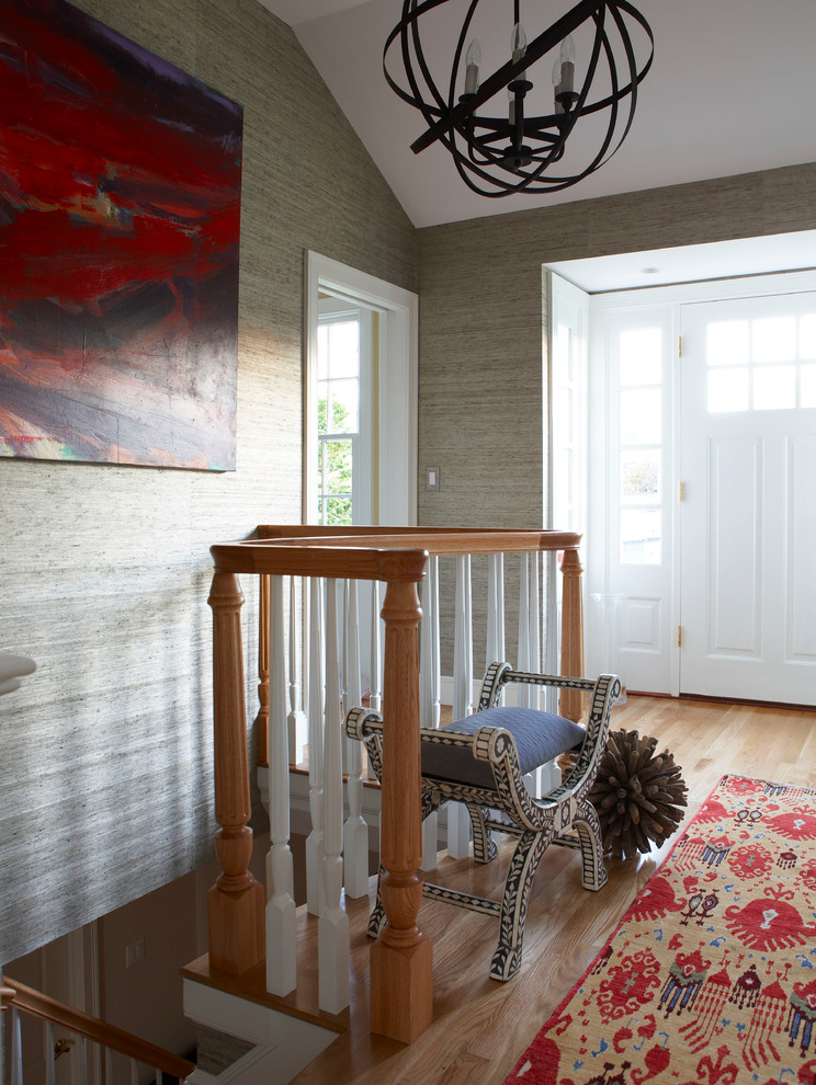 Example of a classic light wood floor entryway design in Boston with beige walls and a white front door