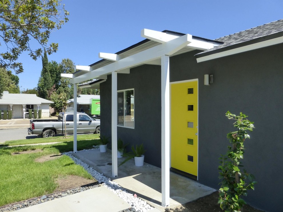 Foto di una porta d'ingresso minimalista con pareti grigie, una porta singola e una porta gialla