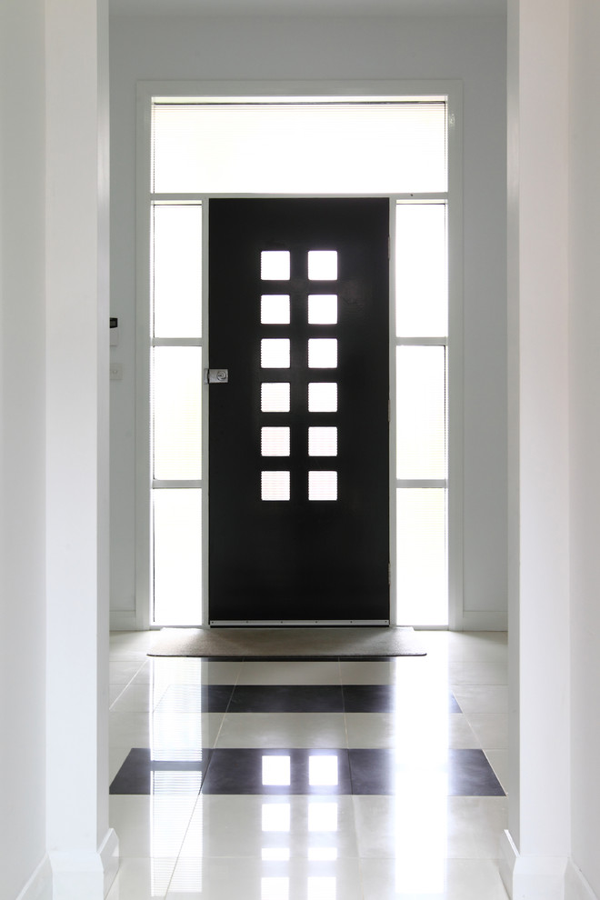 Foto på en stor funkis ingång och ytterdörr, med vita väggar, travertin golv, en enkeldörr och en svart dörr