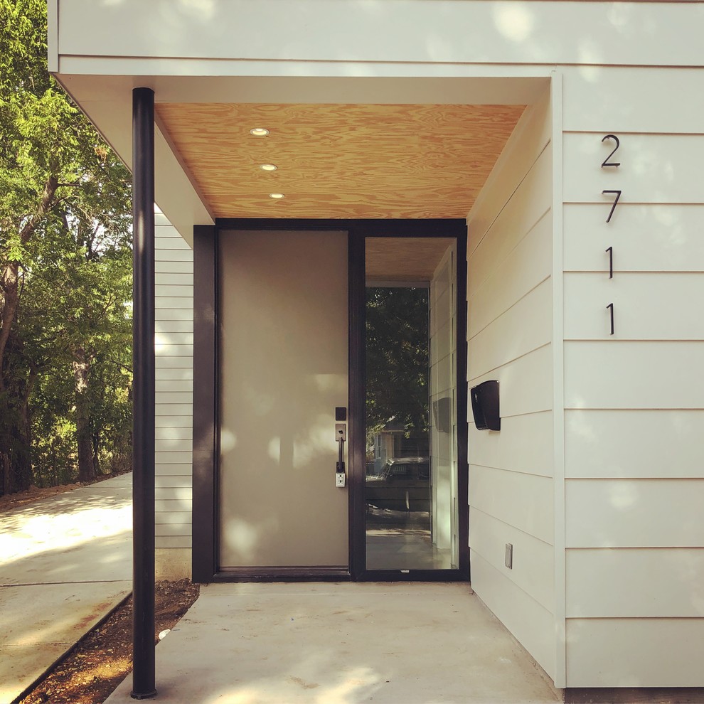 На фото: входная дверь в стиле модернизм с белыми стенами, бетонным полом, одностворчатой входной дверью, зеленой входной дверью и серым полом с
