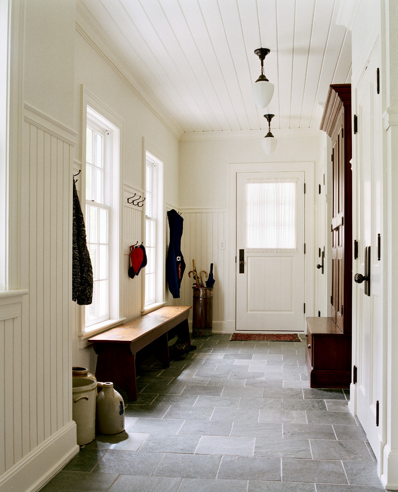 Cette photo montre une entrée chic de taille moyenne avec un vestiaire, un sol en ardoise, un mur blanc, une porte simple, une porte blanche et un sol noir.