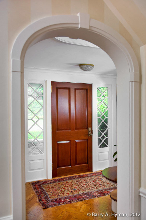 Inspiration pour une porte d'entrée traditionnelle de taille moyenne avec un sol en bois brun et une porte en bois brun.