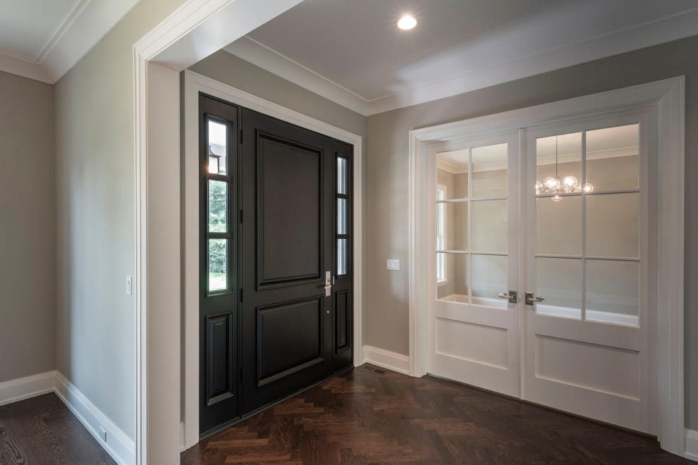 Стильный дизайн: входная дверь среднего размера в классическом стиле с серыми стенами, темным паркетным полом, одностворчатой входной дверью, черной входной дверью и коричневым полом - последний тренд