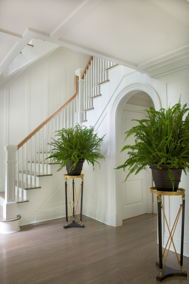 Foyer - traditional medium tone wood floor foyer idea in New York with white walls
