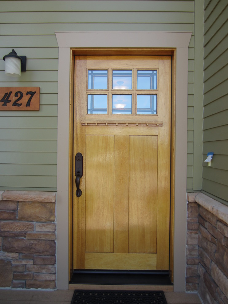 Ejemplo de puerta principal de estilo americano de tamaño medio con puerta simple y puerta de madera clara