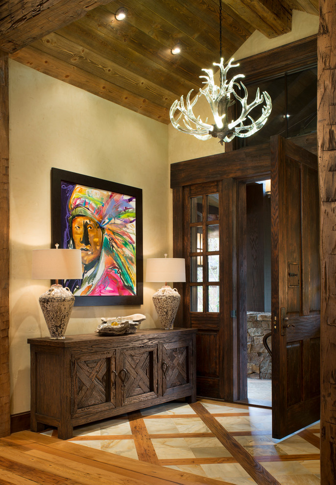 デンバーにあるラスティックスタイルのおしゃれな玄関 (ベージュの壁、無垢フローリング、濃色木目調のドア) の写真