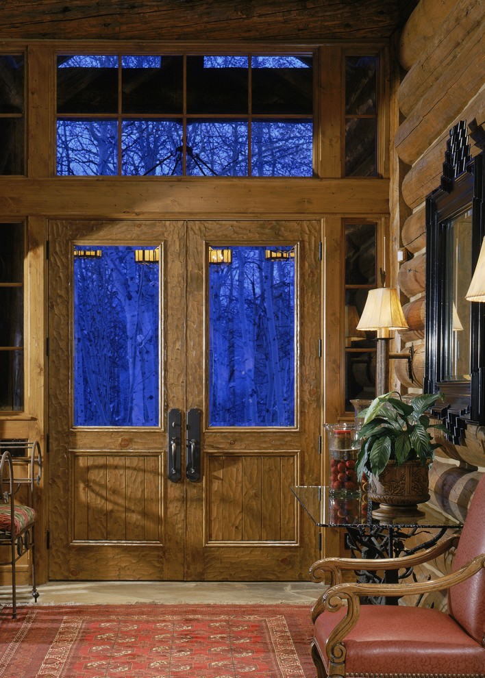 デンバーにある高級な中くらいなラスティックスタイルのおしゃれな玄関ドア (茶色い壁、ライムストーンの床、木目調のドア) の写真